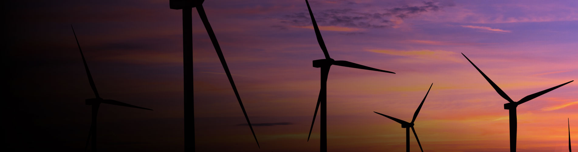 turbinas de energia eólica no mar com céu avermelhado no horizonte