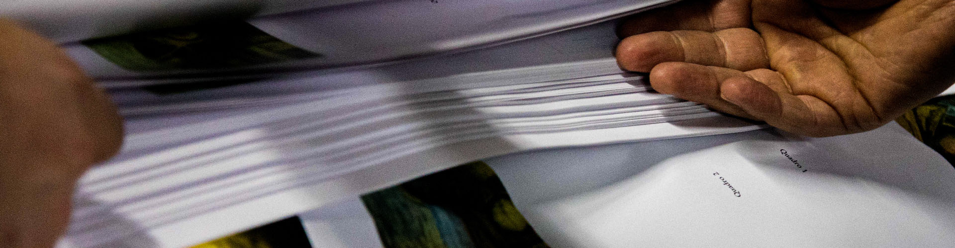 Pepéis e mãos amparando nova obra da Vozes